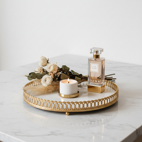 Gold accent decorative tray styled on marble surface with candle and dried flowers